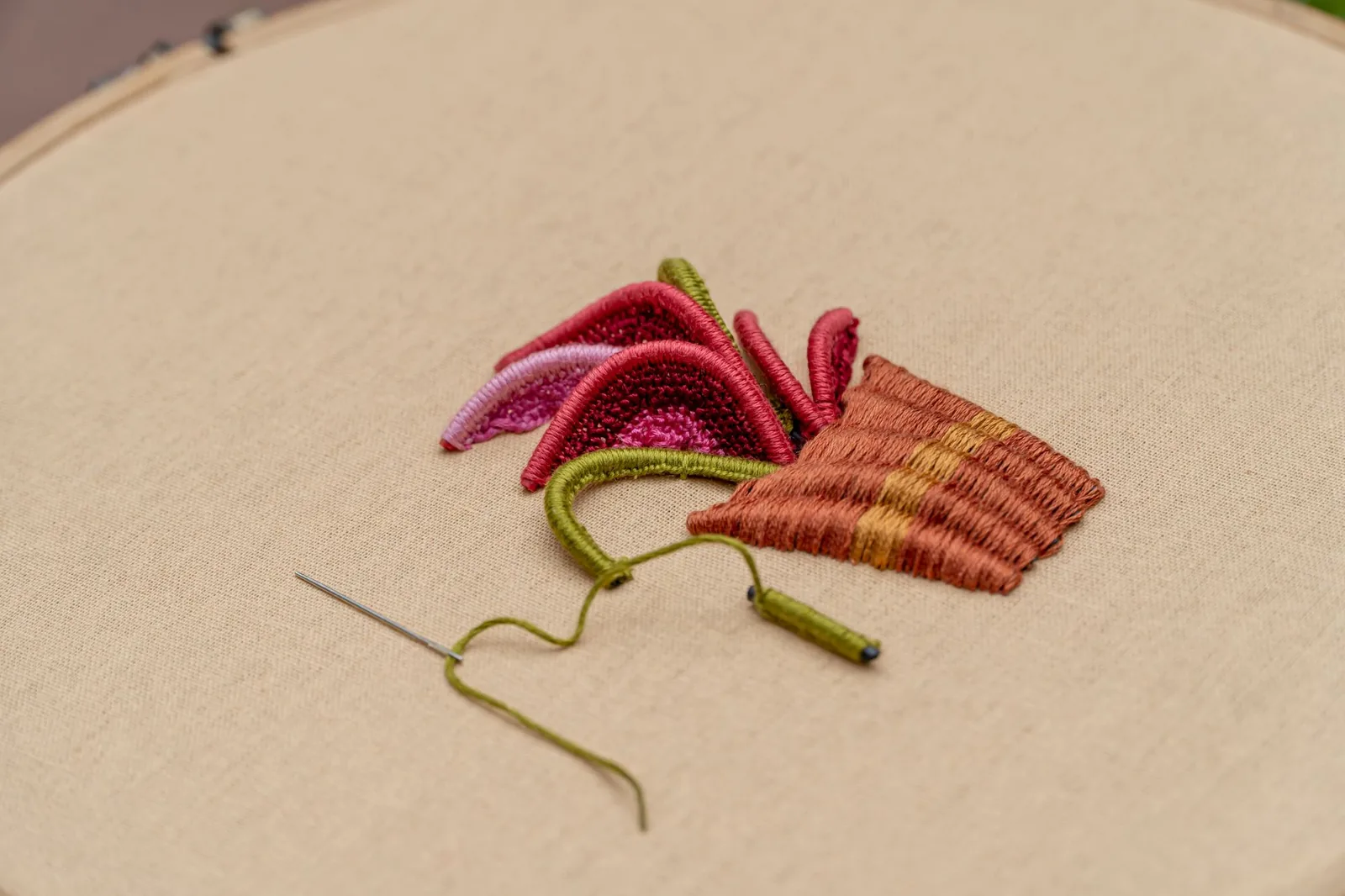 Detaliu de broderie pe material, cu relieful firelor vizibil