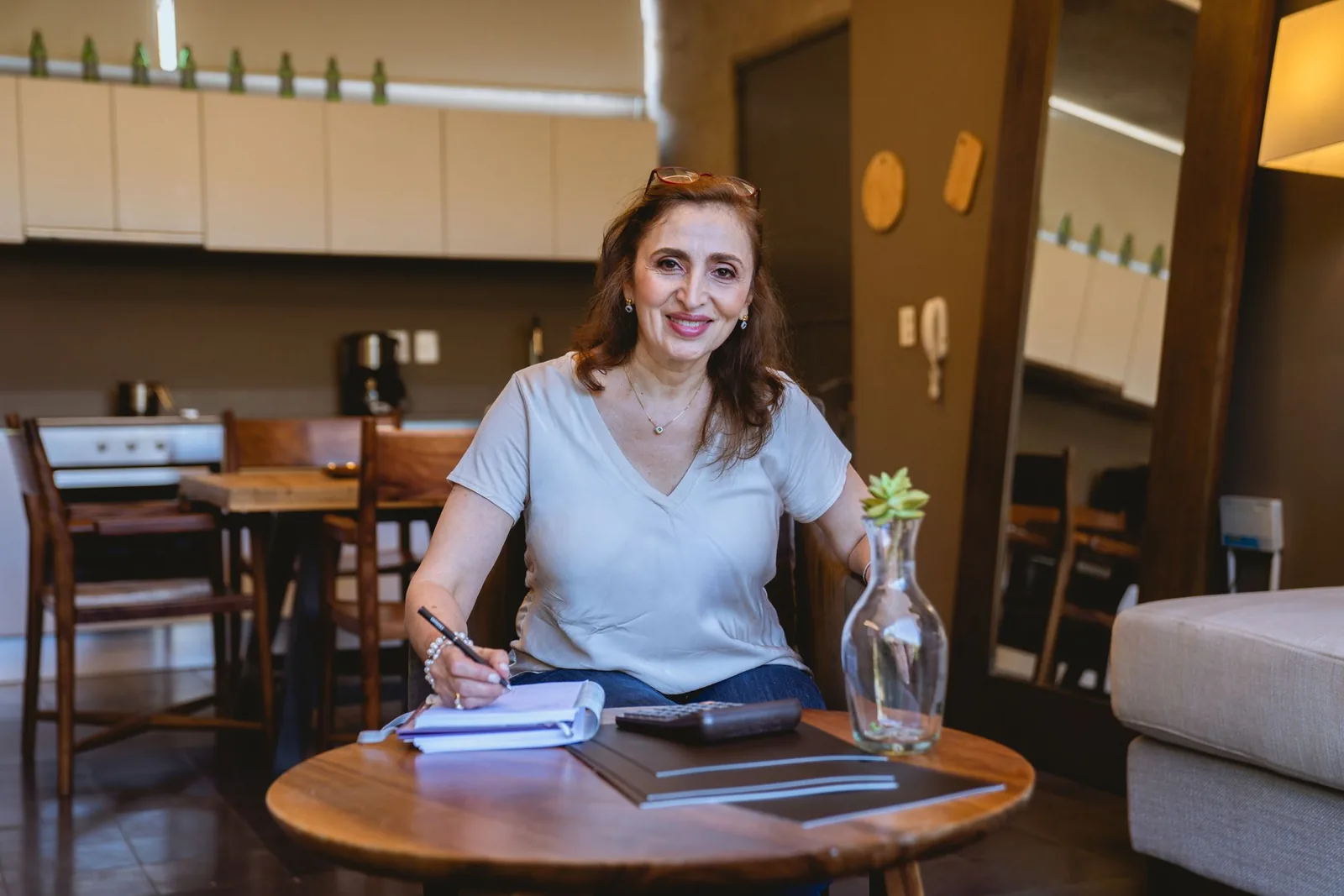 Femeie în vârstă scriind într-un caiet, în bucătărie