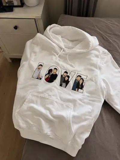Bluză albă cu LOVE în litere aplicate, aşezată pe pat